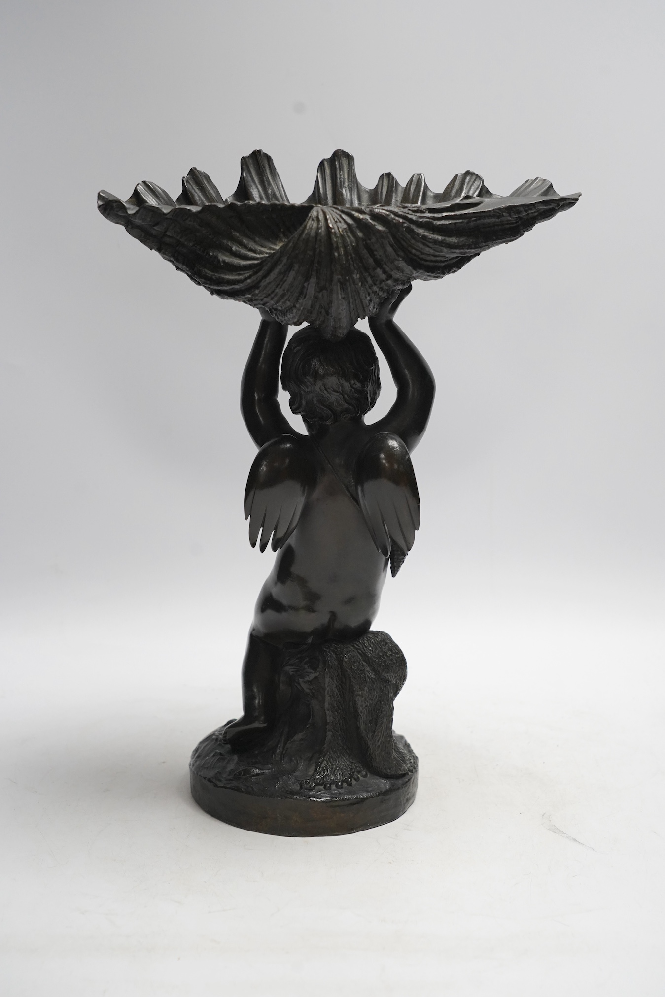 A 19th century bronze figure or centrepiece in the form of putti holding a shell, 34cm